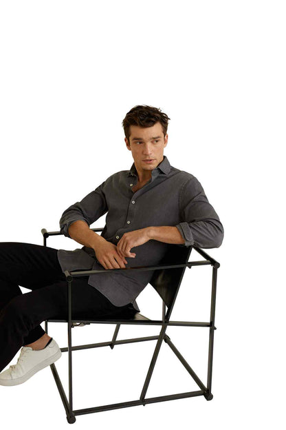 Open grey button-up shirt on seated model, long sleeves and button front