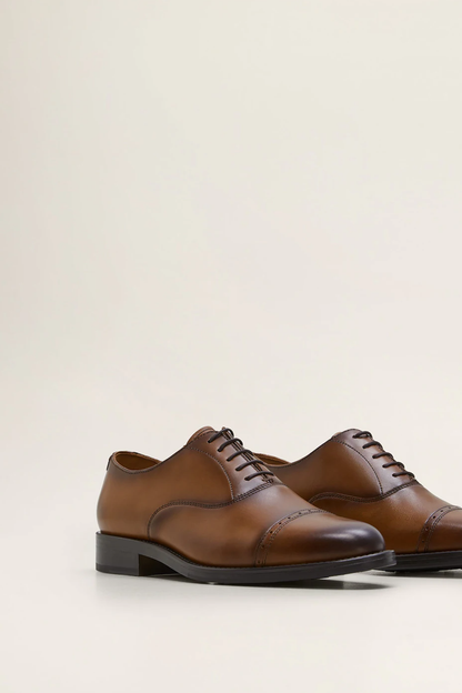Brown leather lace-up oxford shoes, angled pair view with black sole