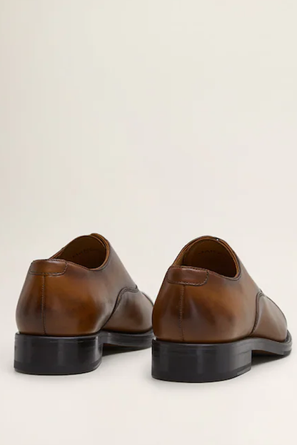 Brown leather lace-up oxford shoes, rear heel view of pair with black sole