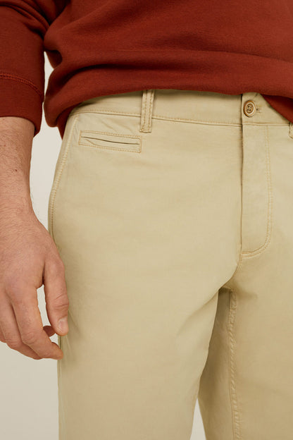 Beige shorts close-up: zip fly, belt loops, and front pockets