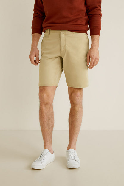 Beige knee-length cotton shorts with front pockets and belt loops