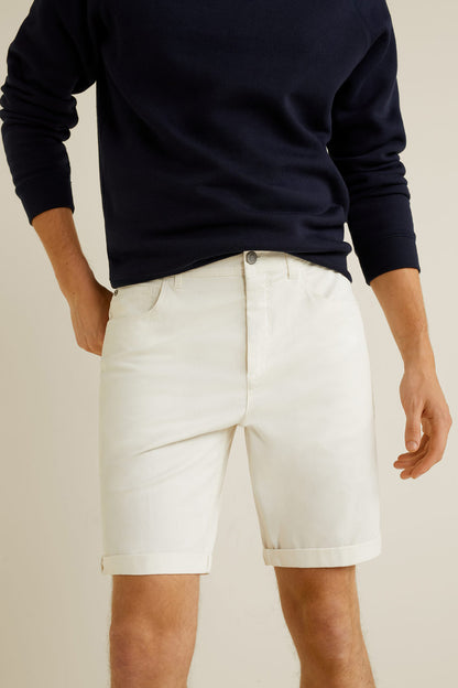 White denim shorts with front button closure and seam detail at the leg