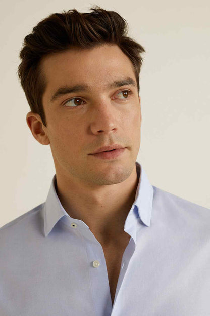 Men's sky-blue dress shirt close-up, point collar and button placket