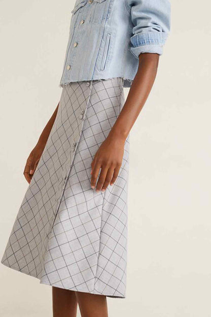 Side view of light blue denim jacket and white grid midi skirt, draped A-line