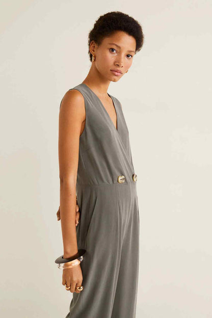 Gray sleeveless V-neck jumpsuit with button waist detail and draped front.