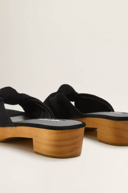 Black knot slide sandals showing chunky wooden heel and textured strap