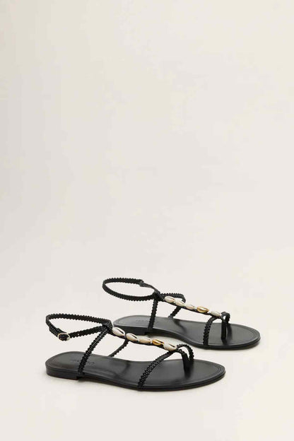 Pair of black flat sandals with braided straps and gold shell bead details