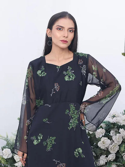 Nazmina dress close-up: green floral pattern on dark body, sheer sleeve overlay