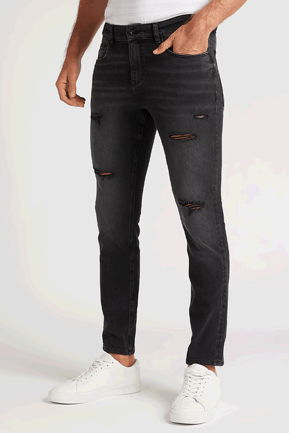 Black distressed straight jeans with multiple orange-brown rips and belt loops