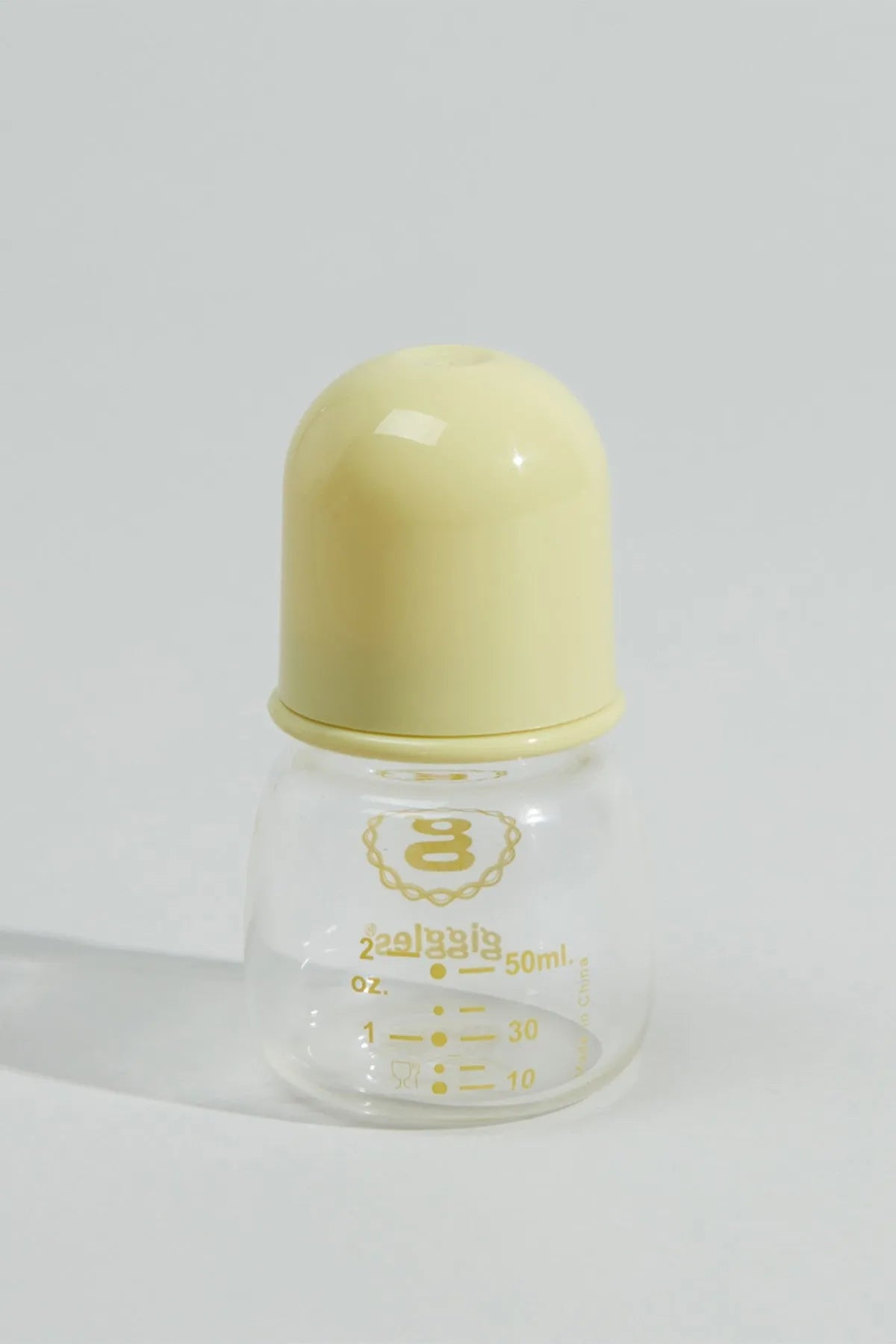 Clear baby bottle with yellow cap, 'giggles' logo, and volume measurement marks