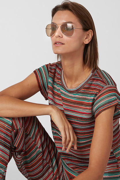 Splash sunglasses on face with thin gold frame and peach-tinted lenses