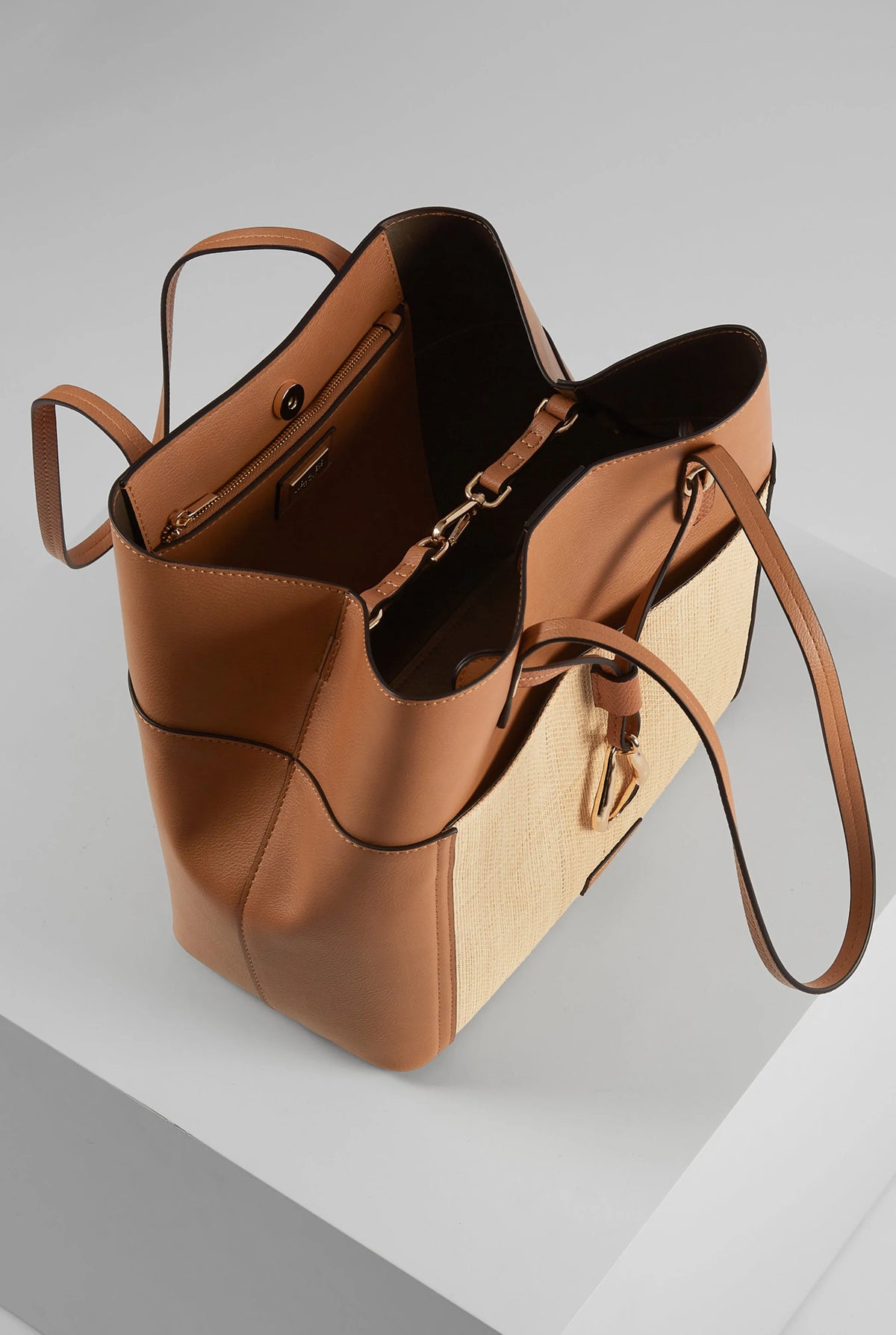 Brown and tan tote bag with open top, leather lining, and single shoulder strap