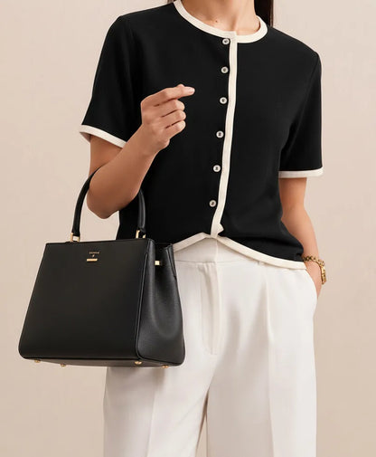 Black fitted button-front short-sleeve top with white contrast trim and round neckline