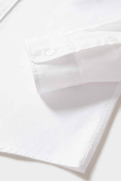 White button-up shirt fabric and hem detail, showing stitching and buttons