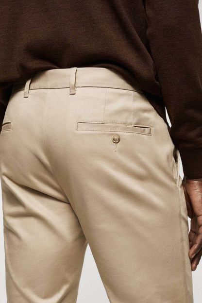Beige chino pants close-up of waistband and back pocket with button