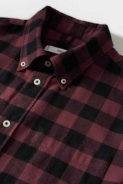 Red-and-black plaid button-up shirt fabric close-up, button placket detail