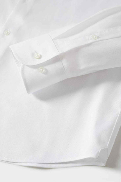 White dress shirt cuff detail with button and folded sleeve