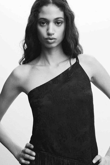 Black one-shoulder fringe jumpsuit, close-up neckline and fitted bust