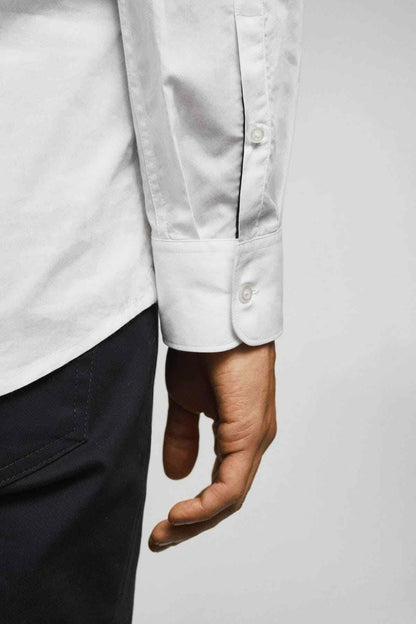 White dress shirt cuff detail with buttons and long sleeve hem