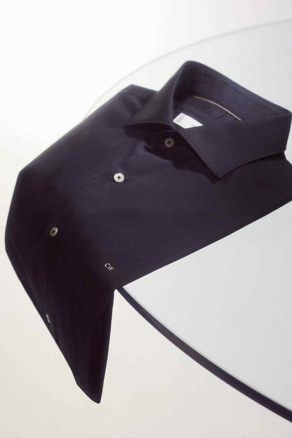Navy button-up shirt folded, showing point collar and button placket