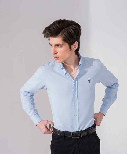 Light blue fitted button-up shirt with long sleeves and button front, small chest logo.