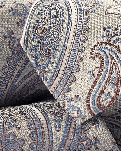 Paisley necktie closeup, blue and red motifs on light beige fabric
