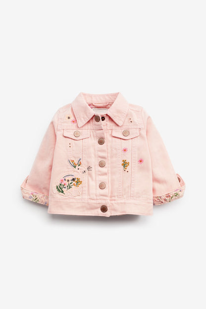 Pink denim jacket with colorful embroidered patches and button front