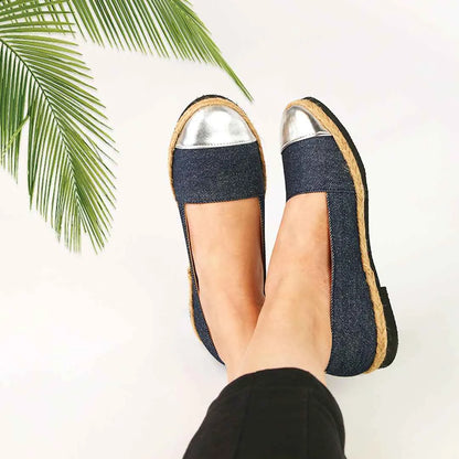 Blue denim slip-on flats with silver metallic toe caps and tan edge