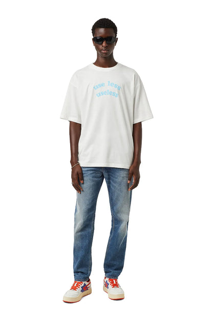 Diesel white sneakers on model's feet with orange laces and blue side logo
