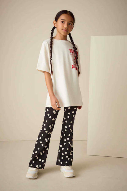 Kids graphic T-shirt with black polka-dot flared pants, full outfit front view