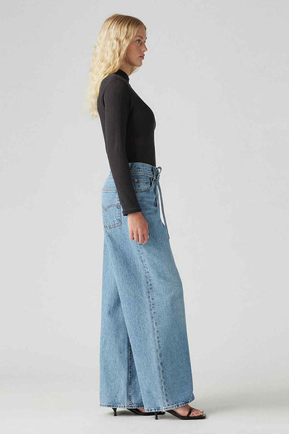 Blue denim jeans with wide-leg fit, side view