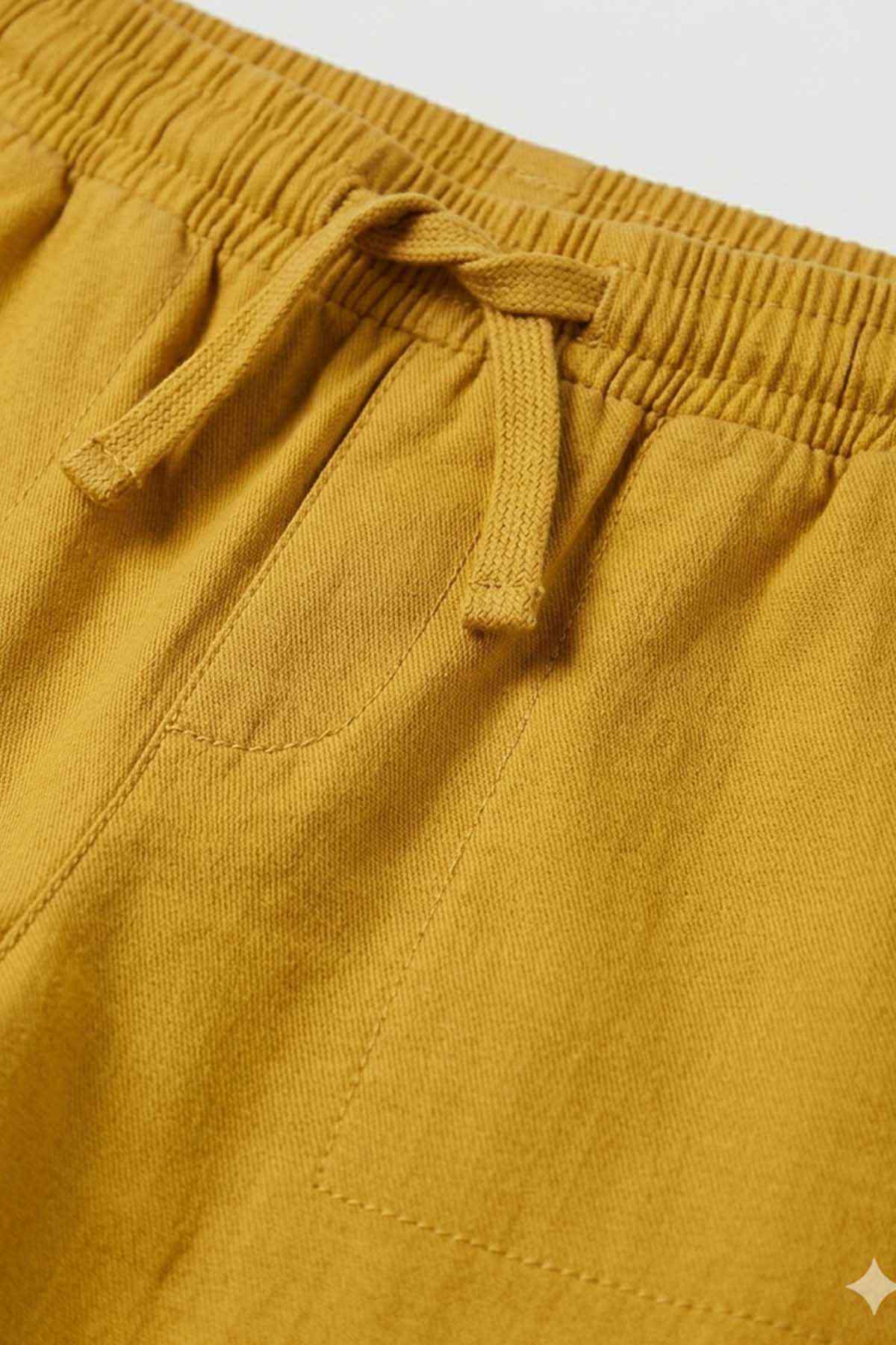 Close-up of mustard elastic waistband and drawstring on kids' pants