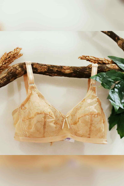 Beige lace bra with lace cups, center bow, and adjustable shoulder straps