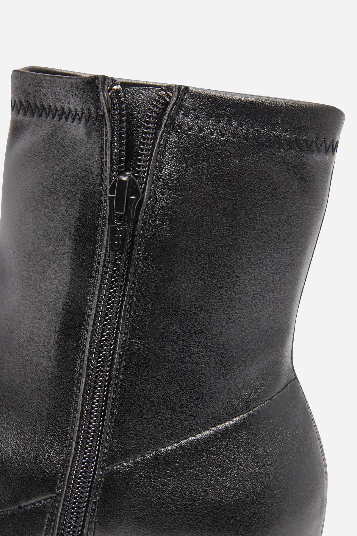 Black leather ankle boot upper with silver side zipper close-up