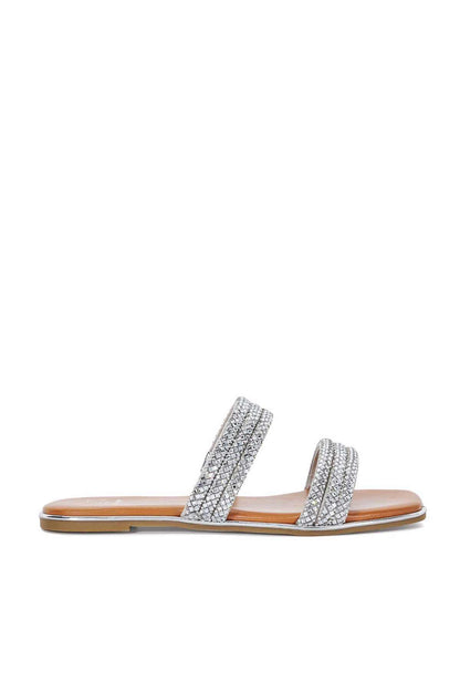 Silver rhinestone slide sandal with two wide straps and tan outsole, side view