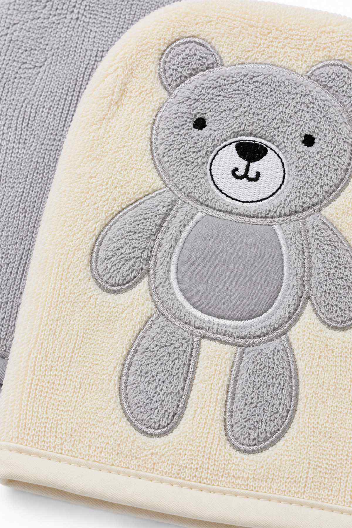 Cream baby blanket with gray teddy bear applique