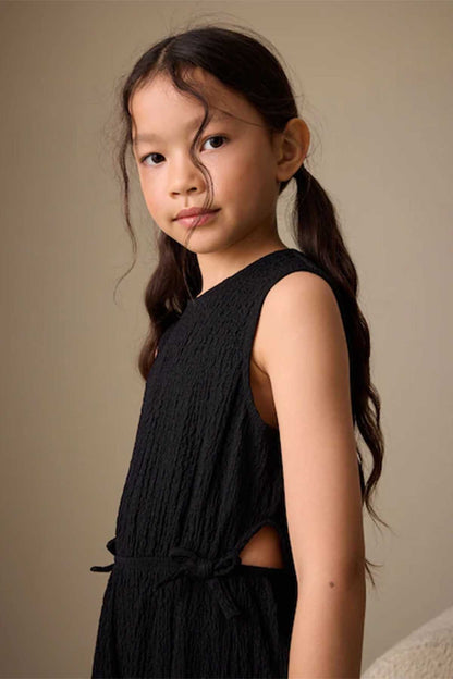 Kids black textured sleeveless jumpsuit with tie waist, side view