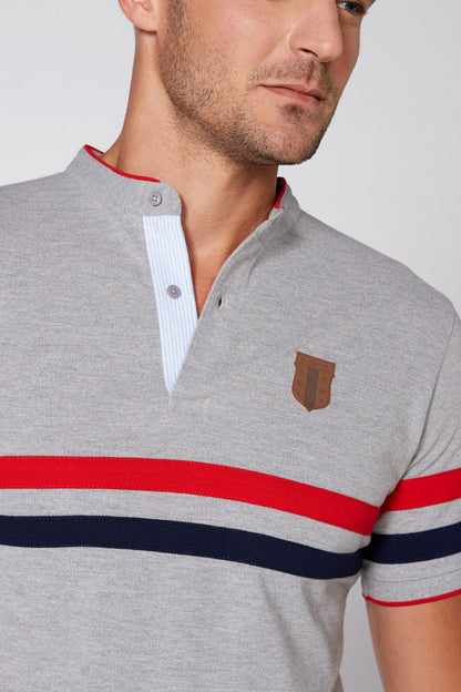 Grey polo shirt close-up: striped collar trim and small brown logo on chest