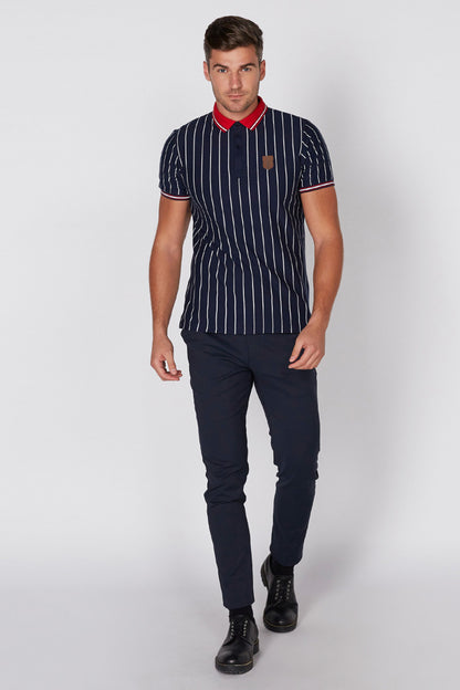 Navy striped polo shirt with red collar and sleeve trim, worn with dark pants