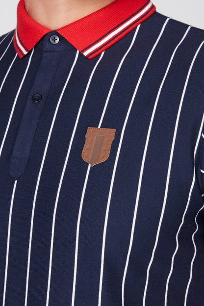 Navy polo close-up with white vertical stripes, red collar, button placket, chest patch
