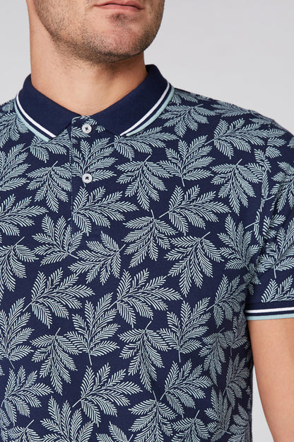 Navy leaf-print polo shirt, striped collar and white button placket close-up