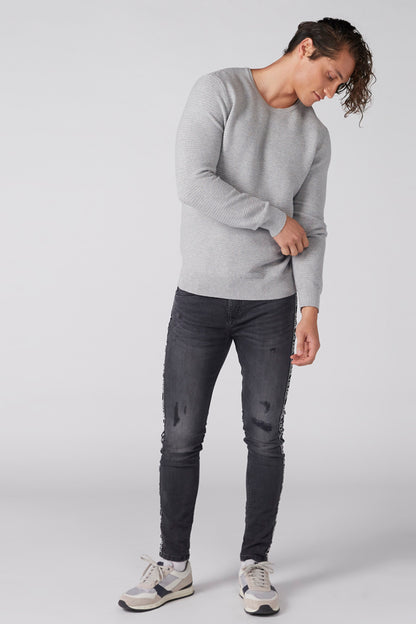 Heather grey crewneck sweater, long sleeves, worn with dark jeans