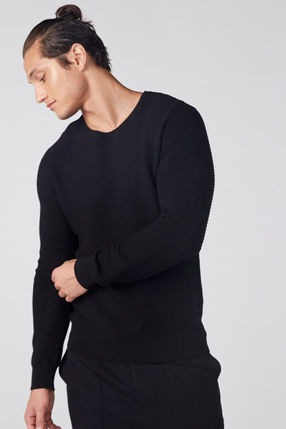 Black long-sleeve knit top with crew neck, ribbed cuffs and hem