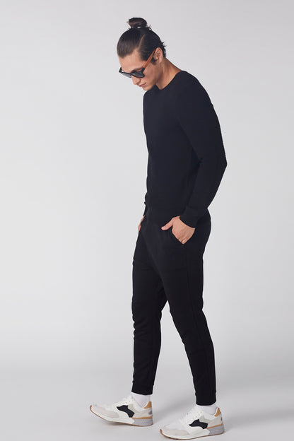 Black long-sleeve knit top with crew neck and straight hem