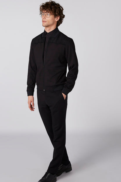 Men's black zip-up jacket with ribbed cuffs, side view