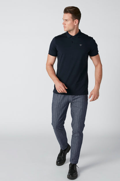 Men's dark navy polo shirt with short sleeves, worn with striped pants