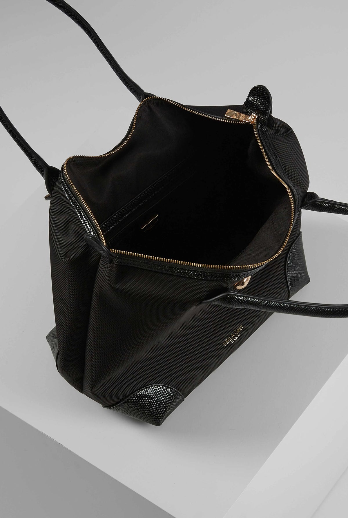 Black tote bag open view showing inner zipper pocket and top zipper