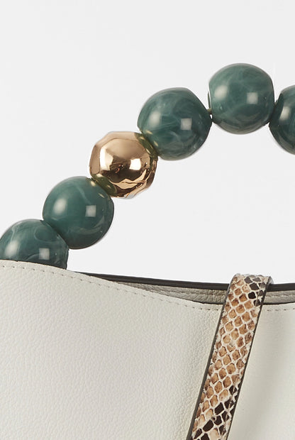 Green and gold bead handle close-up with leopard-print strap and cream bag edge