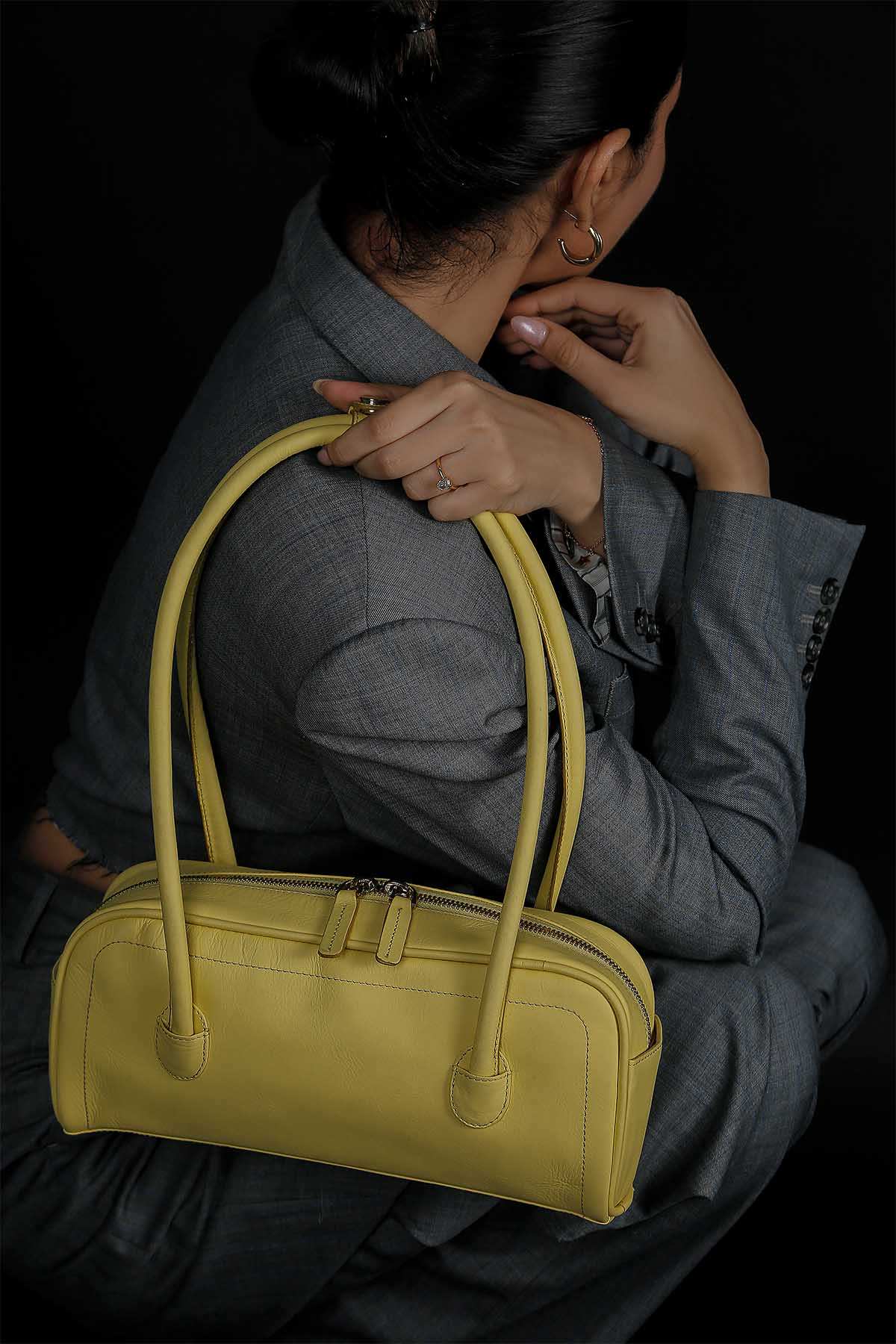HIBISCUS butter yellow handbag held by hands, zipper top, rounded short handles