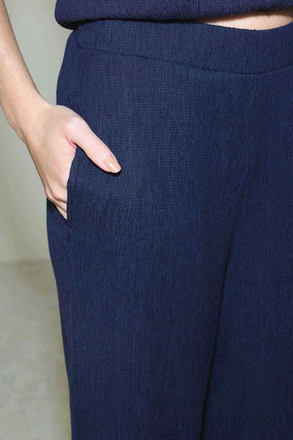 Navy textured trousers with elastic waistband and smooth, straight leg shape